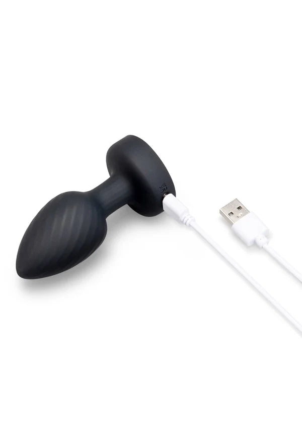 Black silicone butt plug with a textured grip, connected to a white USB charging cable, shown on a solid white background.