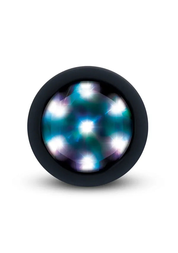 A round black plug with a textured, glossy surface featuring a pattern of glowing blue, teal, and white light spots, shown on a clean white background.